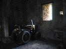 A tractor sits forgotten in the dark